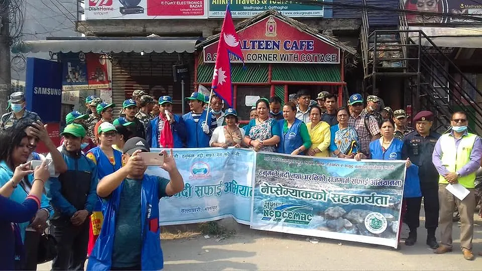 Volunteers in green caps with the Hanumante River clean-up banner
